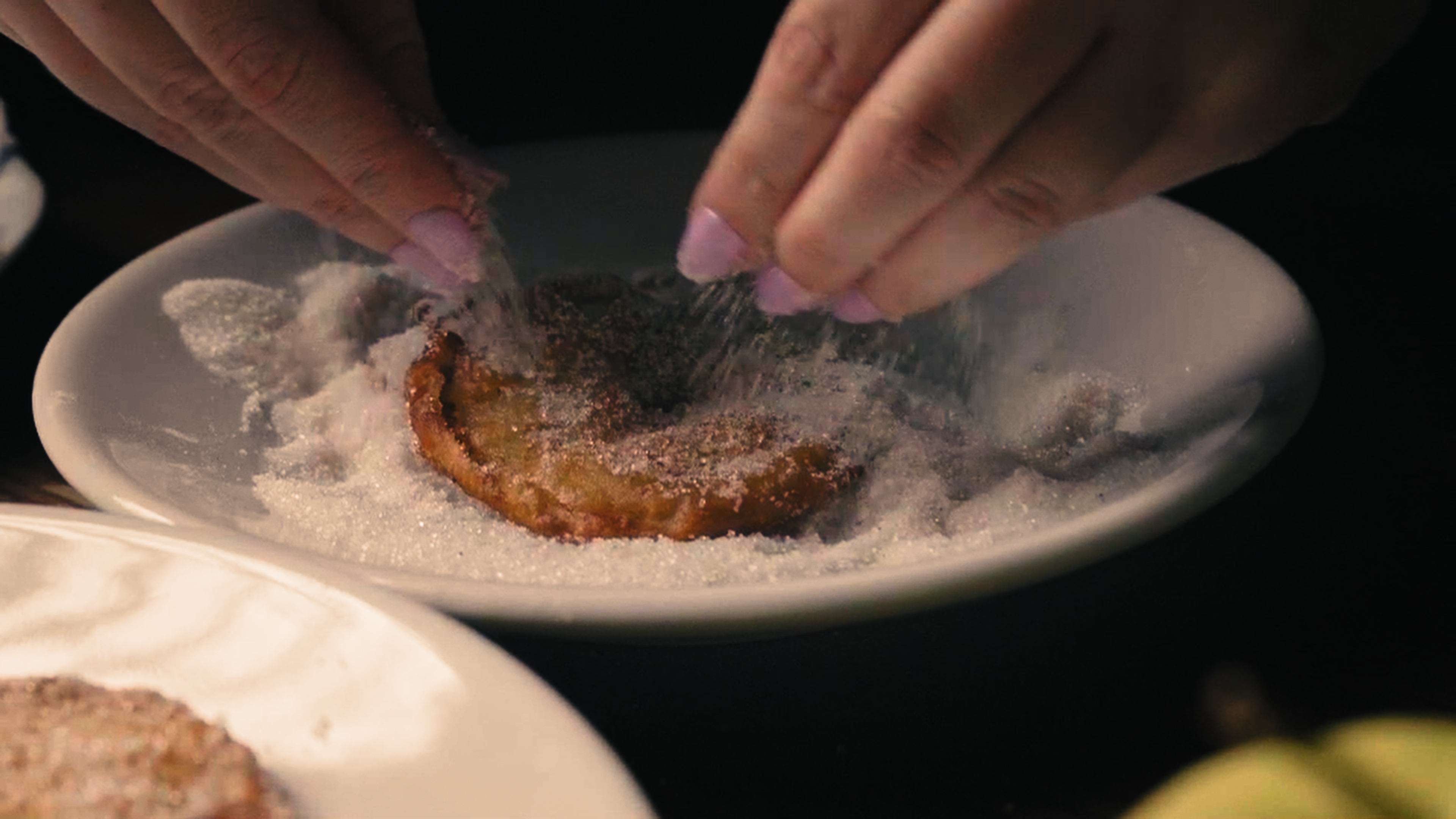 Lo zucchero sulle frittelle appena fritte